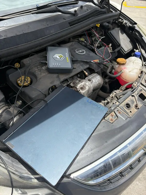 Equipo de reprogramación conectado a la centralita en el vano motor de un coche